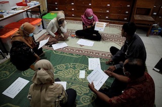 RE-ORG team from Museum Manusia at the Sangiran Early Man Site in Indonesia discuss implementing their project in the storage room.