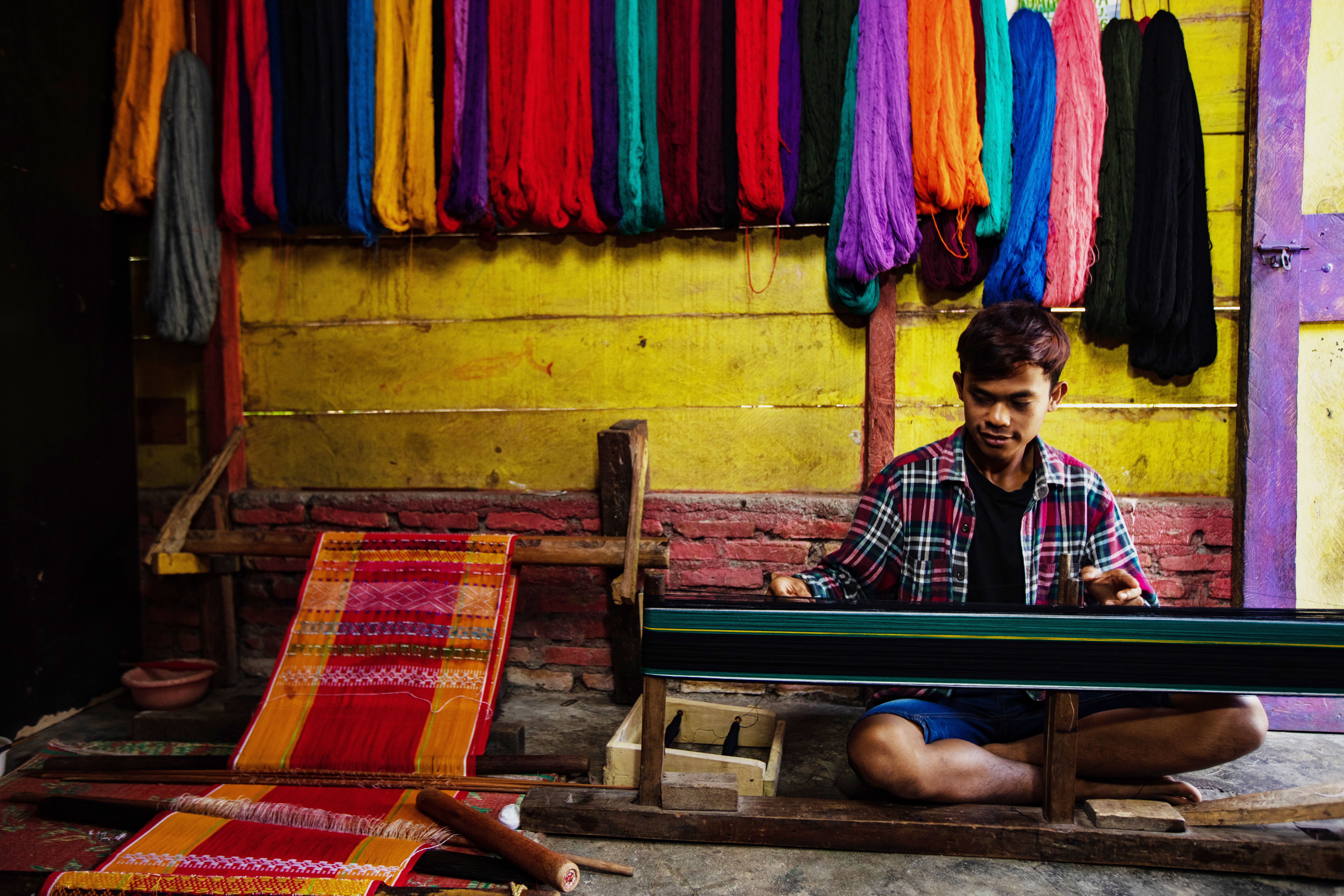 Candro Sitorus, an Ulos weaver from North Tapanuli in North Sumatra province, is performing mangani, a crucial stage in the Ulos-making process. Photo by Simon Siregar. Courtesy of UNESCO.