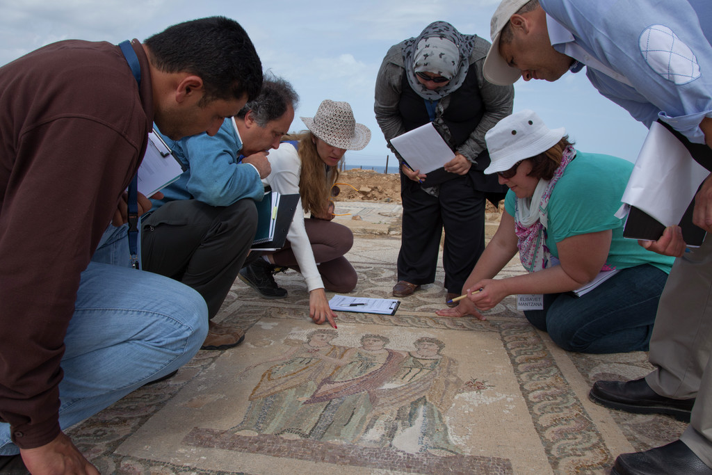   توم روبي يقدم نصائحه للمشاركين في دورة موزايكون (MOSAIKON) خلال تدريب فحص حالة فسيفساء Three Oras في حديقة بافوس الأثرية في بافوس بقبرص، تصوير سكوت س. وارين